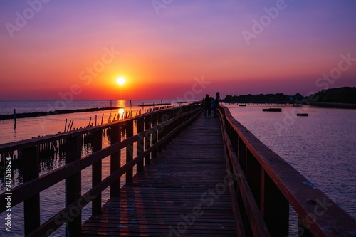 wooden pier at the sea with beautiful bloody sunset. sunset seascape at a wooden jetty. Wood bridge