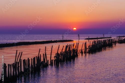 Fototapeta Naklejka Na Ścianę i Meble -  wooden pier at the sea with beautiful bloody sunset.  sunset seascape at a wooden jetty. Wood bridge