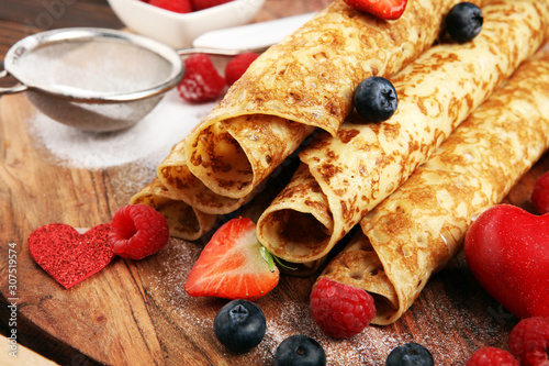 Delicious Tasty Homemade crepes or pancakes with raspberries and mint on rustic background