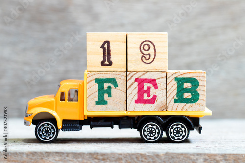 Truck hold letter block in word 19feb on wood background (Concept for date 19 month February) photo