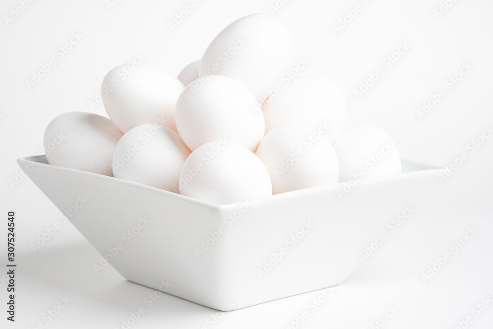 Fototapeta premium Fresh White Eggs Piled On White Square Bowl