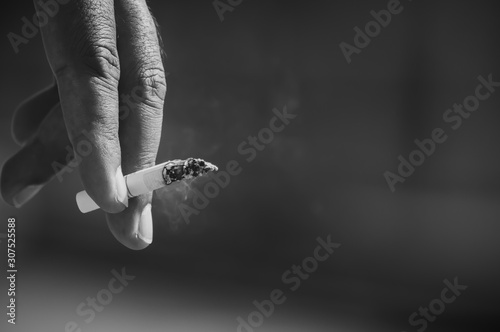 Men's hand is picking up cigarettes.