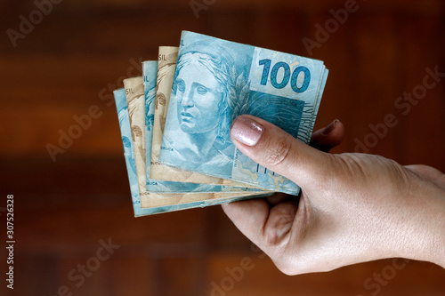 Hands holding Brazilian real notes - Money from Brazil - Notes of Real - Brazil BRL banknote photo