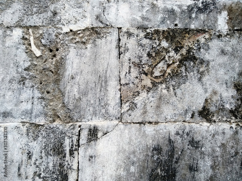 Abstract texture of mossy, porous, cracked and weathered sandstone walls. Wall texture can be used as a wall frame and wall background. Dirty and Old sandstone wall texture background.