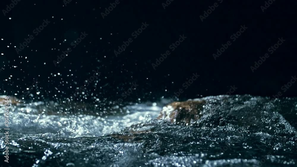 Slow motion of waves on dark water surface with play of flecks of bright light close up. Amazing dramatic natural background. Shooting with 180fps. Epic mystical and magic night view. Crystal clear