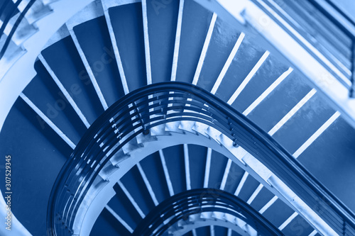 Classic Blue background made for Old blue spiral staircase inside an old house. Color of the Year 2020.
