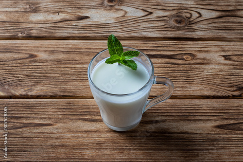 Ayran in a glass, fermented drink, sour milk, decorated with a leaf of mint