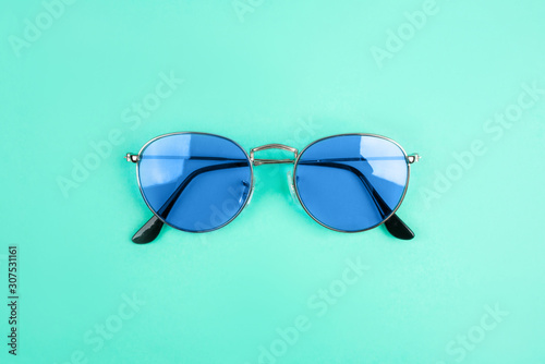 Blue sun-glasses on mint background. Color of year 2020.