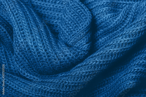 Knitted scarf texture. Classic blue color. The concept of cozy, comfort, warm, softness or winter