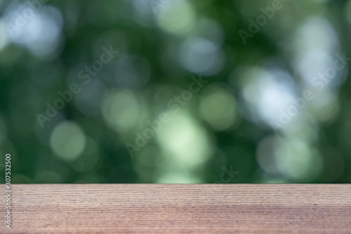 Wood table top on nature green blurred background,for montage your products.