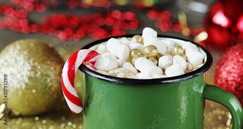 Original cocoa with marshmallows decorated with food confectionery gold balls in an enamelled mug. original decoration idea with food gold. festive mood. copy space