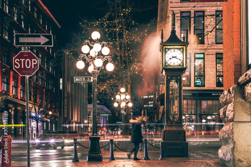 The famous Steam Clock in Gastown in Vancouver city with cars light trails at night