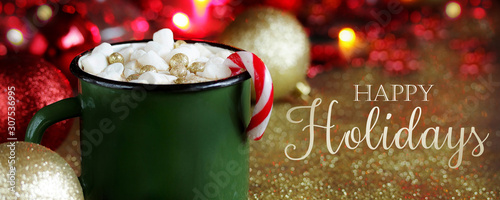 Happy Holidays greeting card banner. Original cocoa with marshmallows decorated with food confectionery gold balls in an enamelled mug. original decoration idea with food gold. 