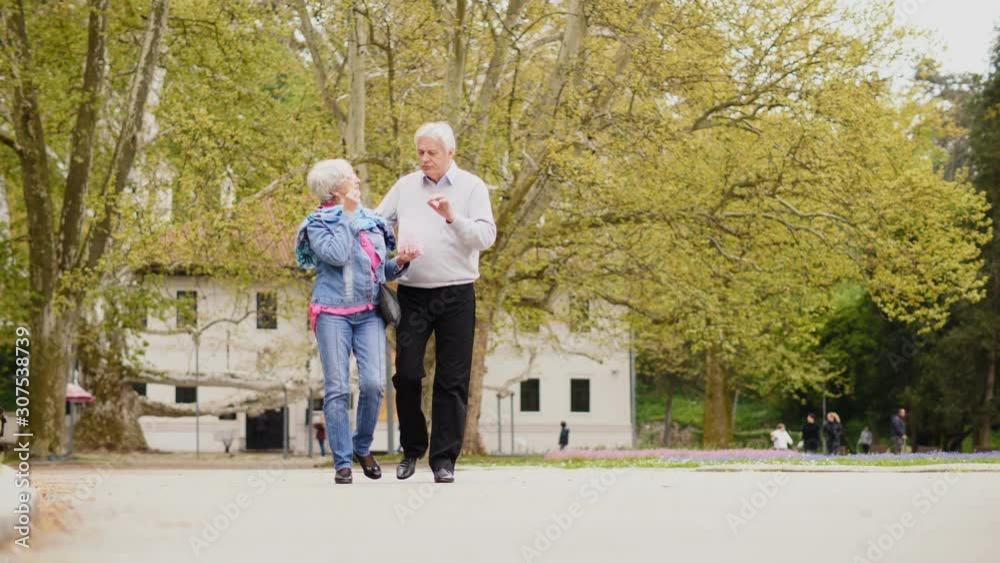 Cheerful senior husband and wife walking and eating popcorn Cheerful senior husband and wife walking and eating popcorn