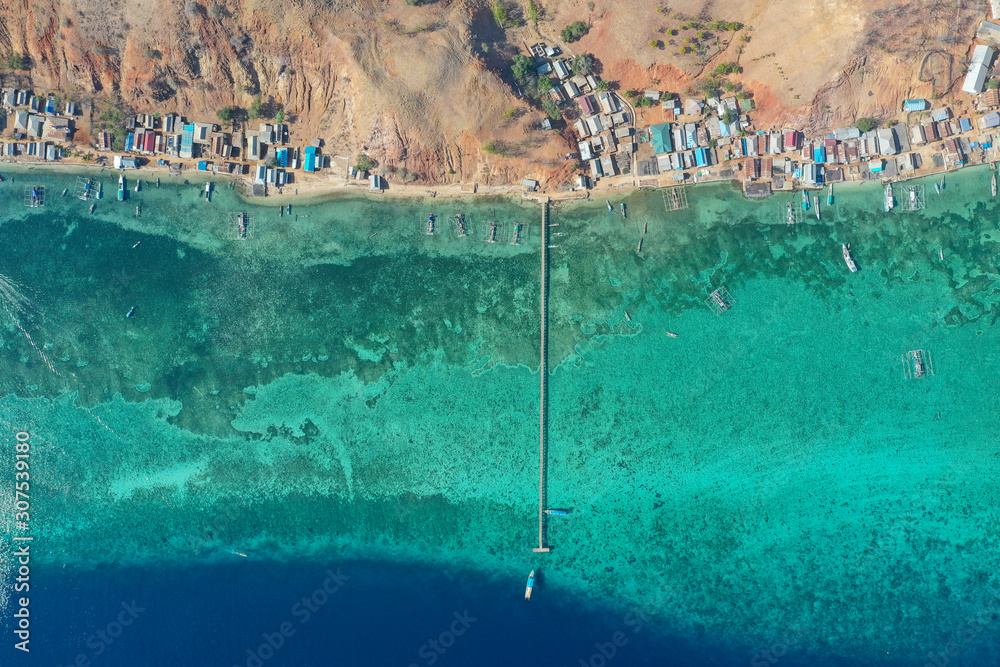 Aerial and top view the beautiful blue ocean and fisherman village at the remote island called Papagarang located in Komodo National Park, Indonesia.