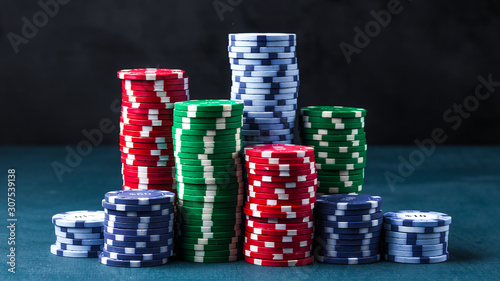 stack of poker chips on a blue table on a black background