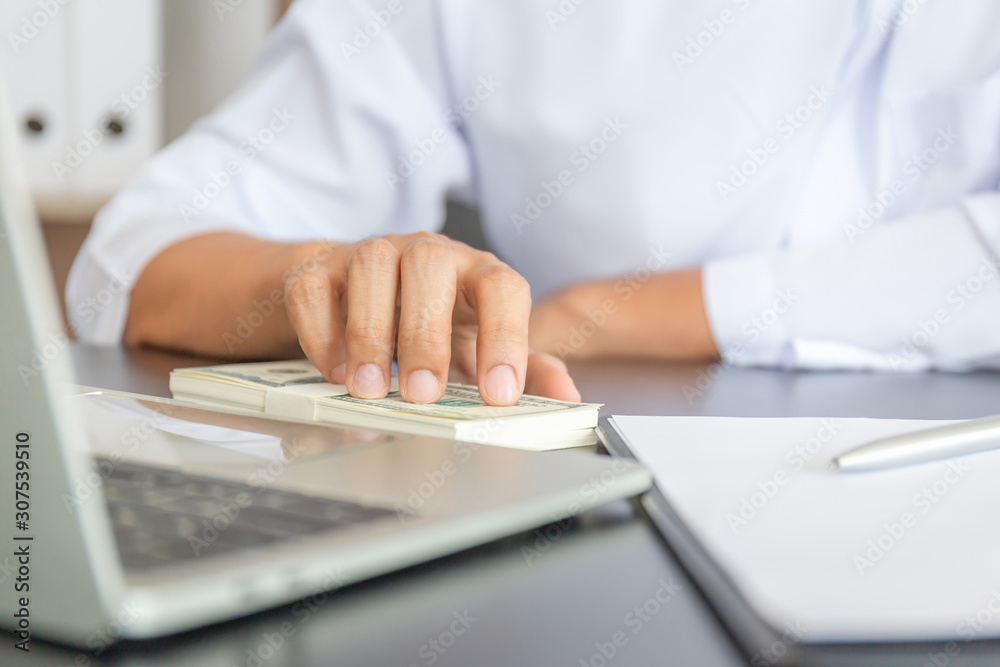 Selective focus of Money banknotes on the table with young business muslim man hand blurred background, Arab finance concept Selective focus of Money banknotes on the table with young business muslim man hand blurred background, Arab finance concept