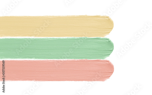 Color corrector strokes isolated on white background. Green peach yellow color correcting concealer cream smudge smear swatch sample. Makeup base creamy texture