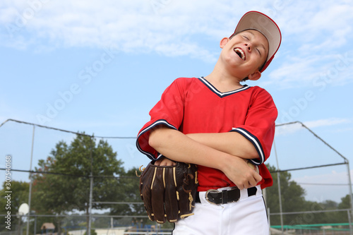 Boy pitcher laughing and holding a baseball