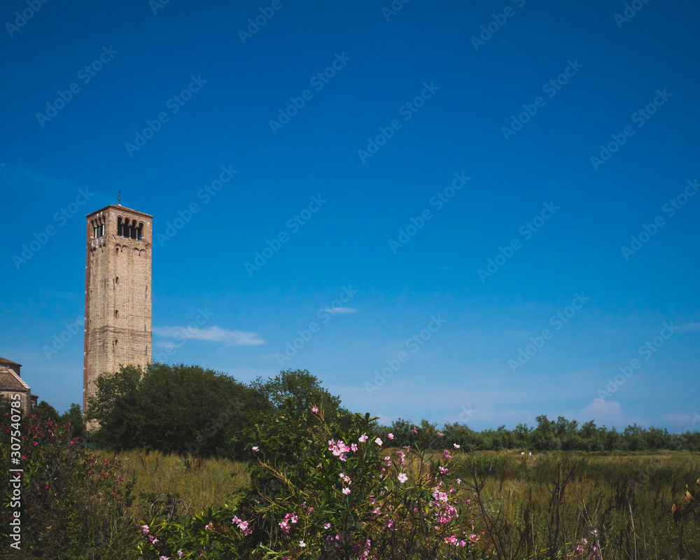 Cathedral of Santa Maria Assunta's bell tower under blue sky on island of Torcello, Venice, Italy