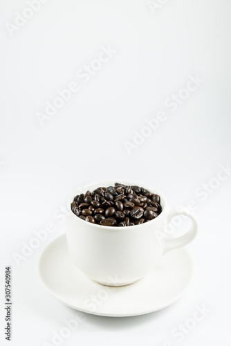 Coffee beans in a white coffee cup.