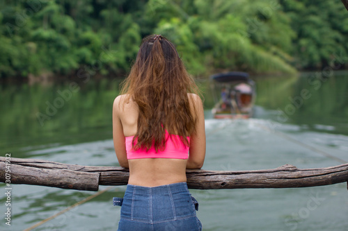 Girl s back view That is happy With tourism The raft in the river in the middle of the forest.