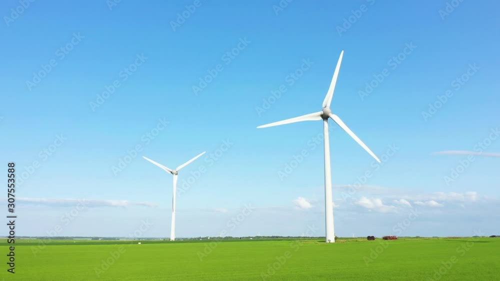 Deux éoliennes dans un champ de lin une journée ensoleillée Deux éoliennes dans un champ de lin une journée ensoleillée