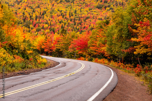 A stunning splash of fall colours driving on Cabot trail, louping Cape Breton, in Nova Scotia is one of the most famous stunning scenic drives in Canada