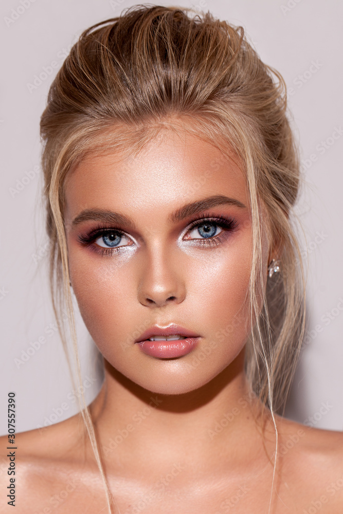 Young blond girl with gentle bridal makeup, perfect skin, rich lashes and locks falling on the face. Young blond girl with gentle bridal makeup, perfect skin, rich lashes and locks falling on the face.