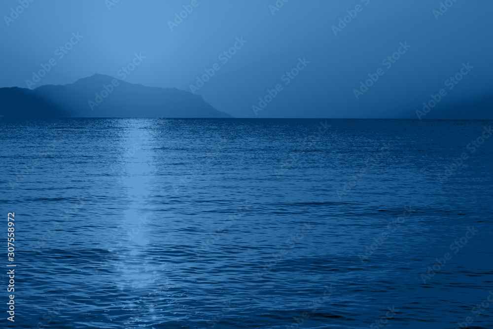 Sunrise over the sea in trendy color classic blue. Photo toned in trendy color of the year 2020. Sunrise over the sea in trendy color classic blue. Photo toned in trendy color of the year 2020.