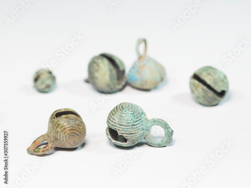 view of ancient bronze little bells covered with green patina isolated on white background.