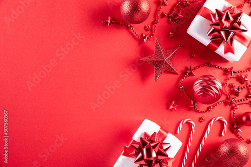 Christmas background concept. Top view of Christmas gift box red and golden ball with snowflakes on light red pastel background.