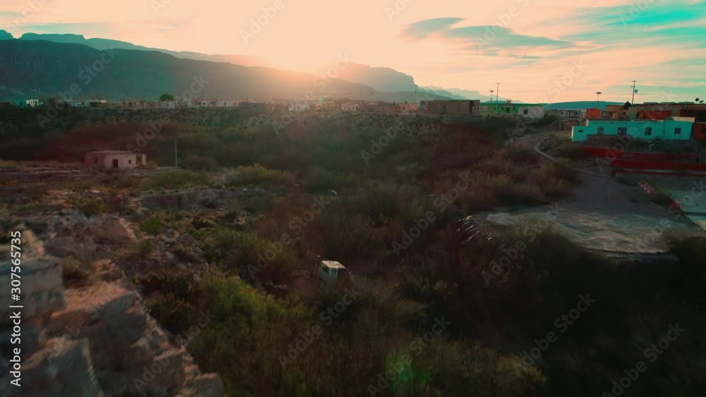 Flying over a jutting rocky cliff toward the small desert border town of Boquillas del Carmen Mexico at sunrise Flying over a jutting rocky cliff toward the small desert border town of Boquillas del Carmen Mexico at sunrise