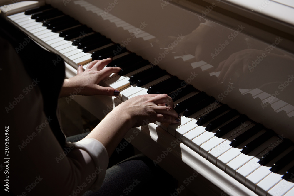 Fototapeta premium Woman hands playing a piano, musical instrument.