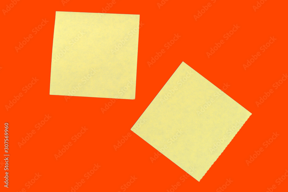 Yellow sticker notes on a bright orange red. Business background, copy space Yellow sticker notes on a bright orange red. Business background, copy space