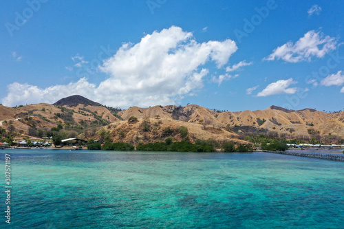 Beautiful view the Manjaja Island with blue and grean ocean, traditional wooden jetty and fisherman village located in Labuan Bajo, Indonesia. The popular destination for tourism.