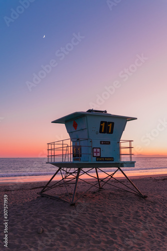 Number eleven blue life guard tower with no diving sign on a beach during sunset under the pink sky in a state park of California