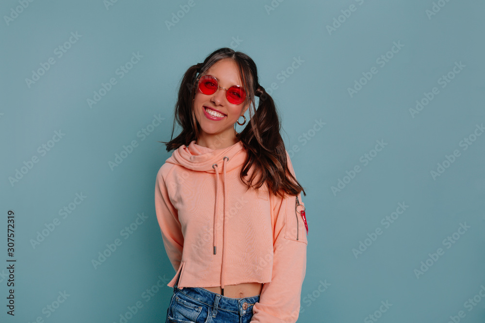 European smiling young woman in funny round glasses laughing to camera over isolated background