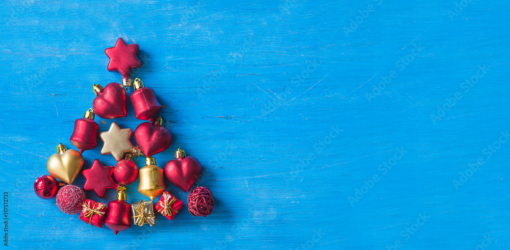 Beautiful Christmas tree of red and golden decorations on the blue paint wooden background. Copy space, flat lay
