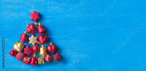 Beautiful Christmas tree of red and golden decorations on the blue paint wooden background. Copy space  flat lay