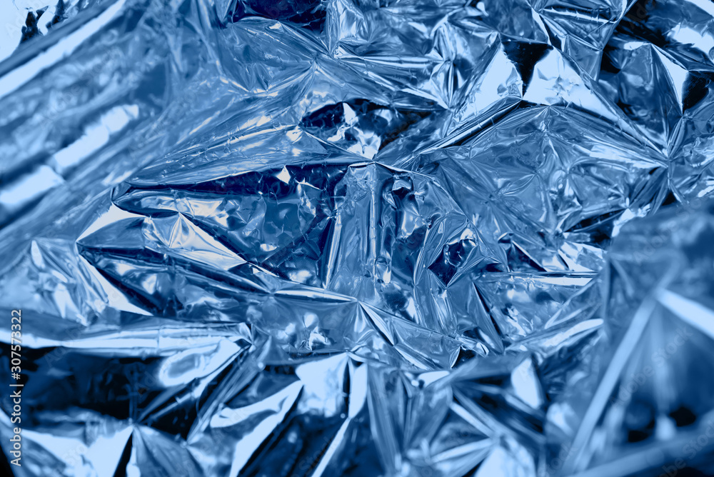 Crumpled silver paper with golographic and chameleon effect, toned blue. Crumpled silver paper with golographic and chameleon effect, toned blue.