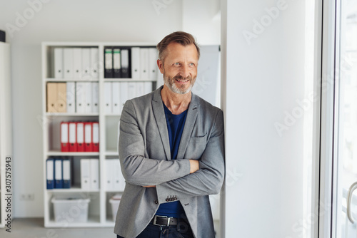 Businessman standing watching with amused smile