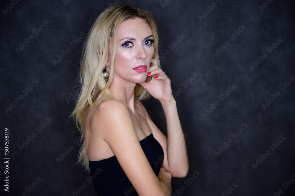 Artistic portrait of a pretty slim blonde model with excellent makeup and beautiful hair in a black top on a gray background. Stylish, fashionable, youth, sexy. This is in different poses. Artistic portrait of a pretty slim blonde model with excellent makeup and beautiful hair in a black top on a gray background. Stylish, fashionable, youth, sexy. This is in different poses.