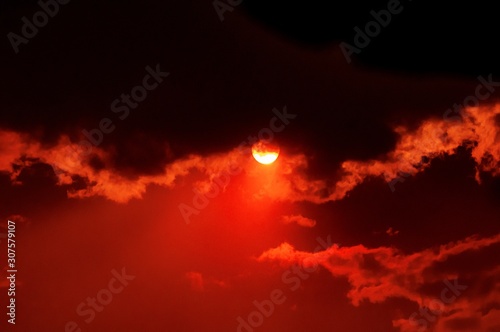 Breathtaking view of the sun setting in the beautiful cloudy red sky © Nicole Avagliano/Wirestock