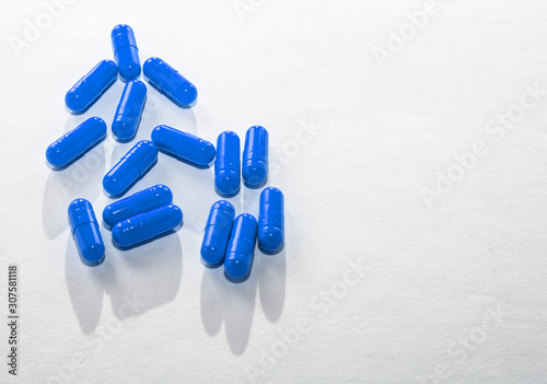 Scattered blue pills on white paper. Layout for special offers, advertising, web background. The concept of medicine, pharmacy, healthcare. Empty space for text, logo. Close-up, isolate of drugs