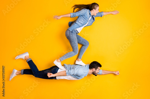 Top view above high angle flat lay flatlay lie full length body size view concept of his he her she beautiful handsome spouse flying isolated on bright vivid shine vibrant yellow color background photo