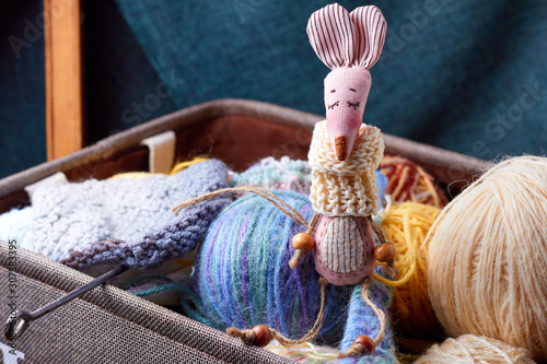 Textile handmade toy of pink lady mouse sitting in a box with balls of thread photo