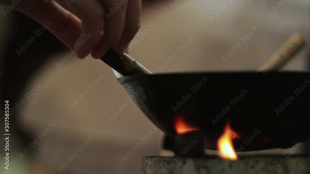 a closeup footage of indonesian batik canting on hot wax wok heated upon small stove, a traditional equipment for painting batik pattern