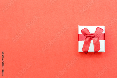 White box with red bow on red background. Concept of Valentine's Day, wedding, birthday, New Year, Christmas and other holidays