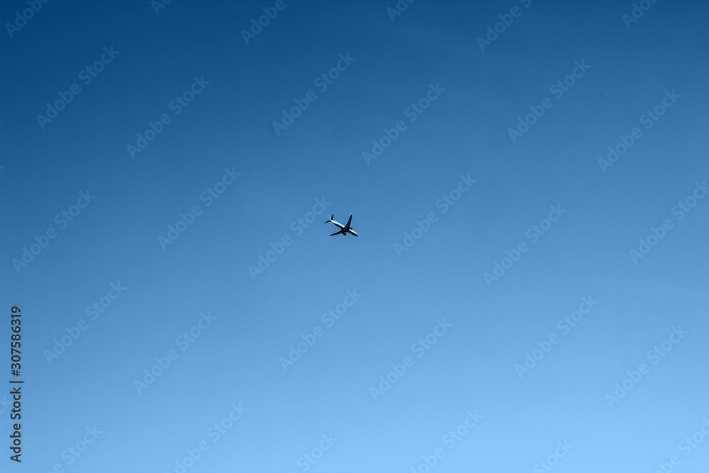Blue clear sky with flying plane, background